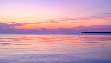 The sun is setting over calm water creating a beautiful blue sky reflection a peaceful sunset over the calm waters reflecting various shades of orange and pink
