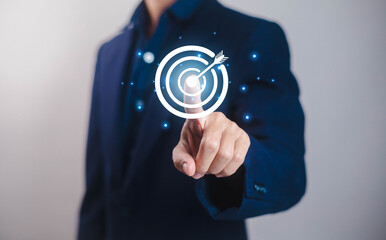 Businessman hand pointing digital target icon with focus on business strategy, marketing goal, innovation, leadership, teamwork and success concept for corporate growth.