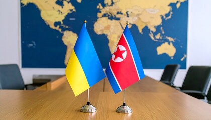 Naklejka premium Ukrainian and North Korean Flags on a Table with World Map Background