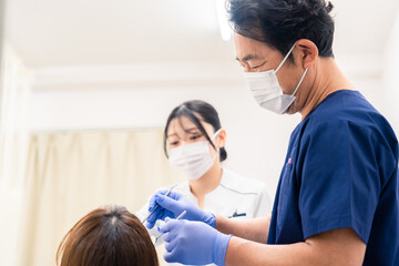 歯科治療をする歯医者の男性