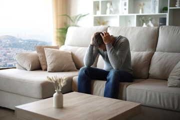 Sad man complaining in a house interior