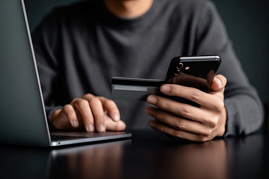 Close-up of person using laptop, phone, and credit card for online purchase - Powered by Adobe