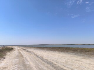 road to the sea. deserted path in a field on a sunny day