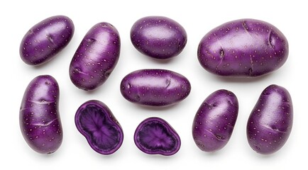 Top view of various whole and halved purple potatoes isolated on a white background.