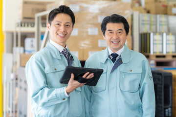 倉庫で打ち合わせをするミドルの作業員