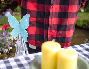 Festive outdoor scene with checkered tablecloth, candles, and whimsical butterfly decoration