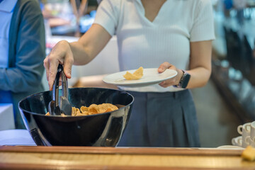 Woman is picking up food from the counter inside a restaurant