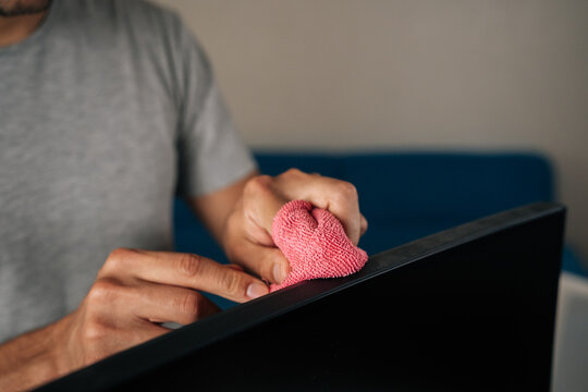 Closeup cropped shot office worker cleaning large curved computer monitor screen with microfiber cloth, ensuring spotless and clear display for optimal viewing. Concept of hygiene and cleanliness. - Powered by Adobe