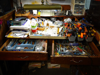 A tinkerer's stacked and cluttered workbench