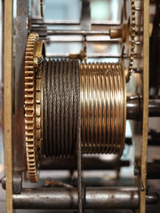 A side view of the gears and cables of a grandfather clock