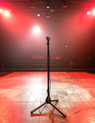 Solo microphone on stage under red lights performance spotlight image