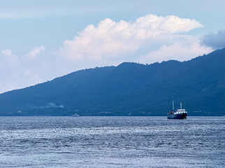 Container cargo ship in the middle of the sea. Concept of transportation, distribution, and sea logistics.