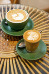 Cup of hot milk latte coffee and piccolo latte coffee on table by the window.