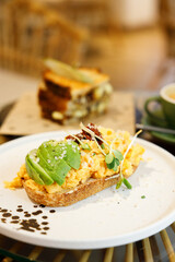 Delicious healthy breakfast plate, sourdough sandwich with scrambled eggs and avocado.