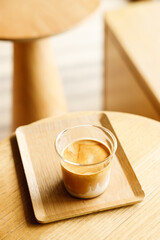 Cup of milk dirty coffee on table by the window.