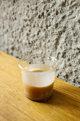 Cup of milk dirty coffee on table by the window.