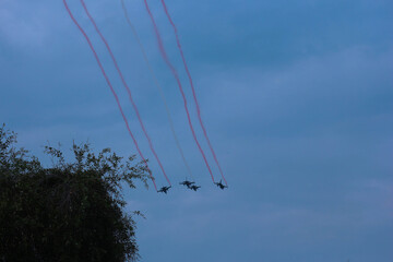 Silhouettes of four fighter planes with smoke in airshow