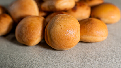 This photo captures a pile of freshly baked, warm bread rolls with a soft, inviting texture and color.