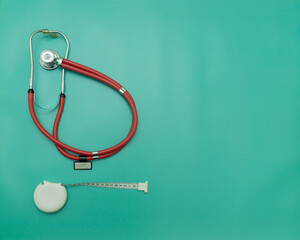 red stethoscope and measuring tape on green Background, Space for Text, Space for Logo