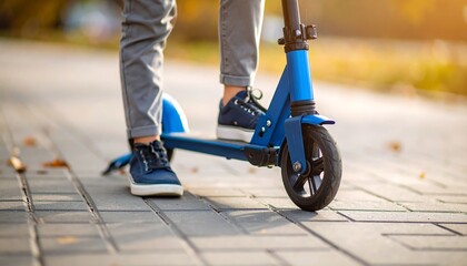 Child on blue scooter in autumn park