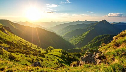 Sun setting over mountains with a clear view of green valley from the mountain top