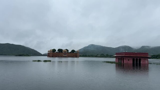 Misty view of Jal Mahal, the Water Palace, floating in Man Sagar Lake surrounded by hills