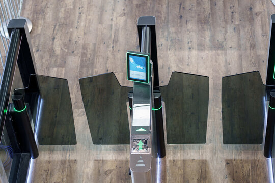 Automated airport boarding gates with QR code scanner and glass barriers