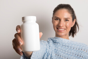 Healthcare and wellbeing. Young woman holding bottle with vitamins, dietary supplements