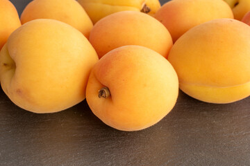Organic ripe apricots on slate stone, macro, top view.