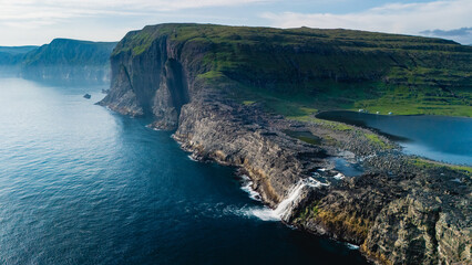 Majestic cliffs and serene waters of the Faroe Islands at golden hour