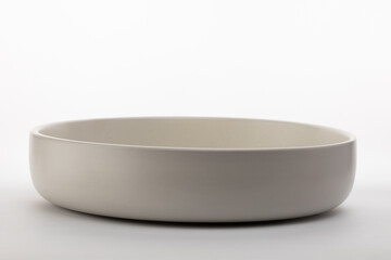 a simple, shallow, light-colored bowl designed to hold food or other small items