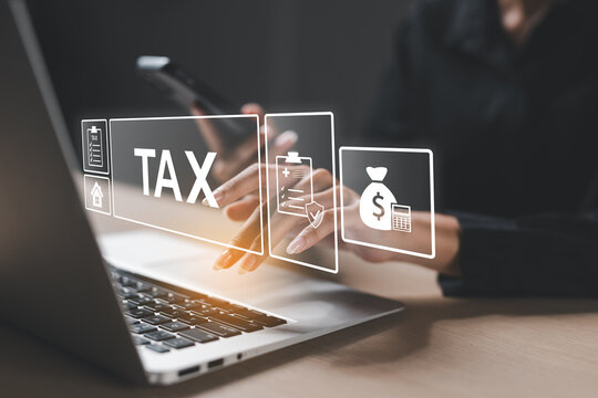 Businesswoman using digital device and laptop for online Tax filing, financial planning, or e-Tax services, representing modern finance and digital transformation concept.