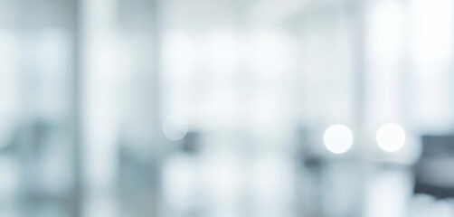 Blurred view of a bright interior space with white and light blue tones, giving a refreshing modern vibe filled with openness, elegance, and calm atmosphere.