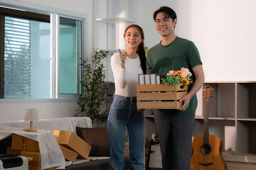 Happy Couple Holding Moving Boxes in Bright Living Room