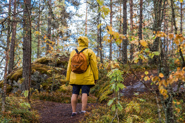 Tourism. Hiking. Ladoga skerries on Lake Ladoga. A male tourist in a yellow raincoat with a...