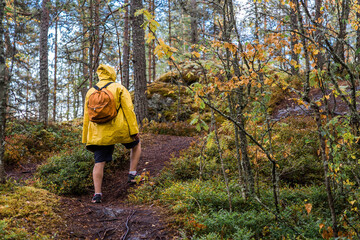 Tourism. Hiking. Ladoga skerries on Lake Ladoga. A male tourist in a yellow raincoat with a...