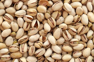 Tasty unpeeled pistachios as background, top view flat lay background