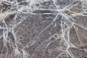 Cracked ice on a puddle texture background cracks and shards on a dark background