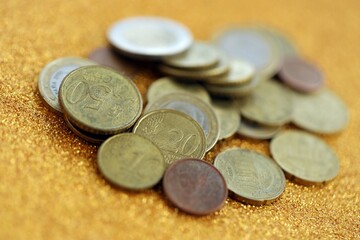 Big amount of euro coins on golden glitter background
