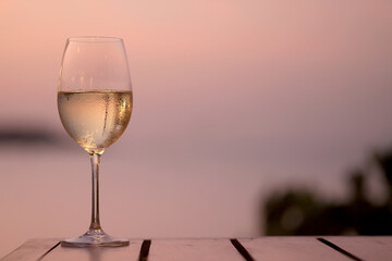 glass of cold white wine on the summer seashore by the water, relaxing by the water, a gentle background of soft color