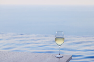 glass of cold white wine on the summer seashore by the water, relaxing by the water, a gentle background of soft color