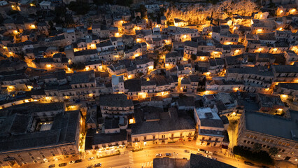 Modica by night – winding streets glowing with golden lights, baroque houses climbing the hillsides, and a timeless Sicilian charm captured from above.