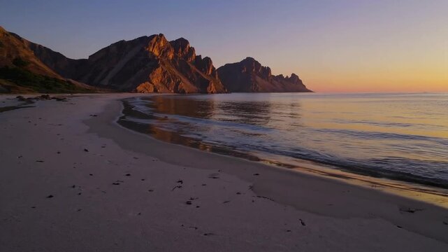 serene stretch of sand adjacent to body of water offering view of elevated landforms at daybreak