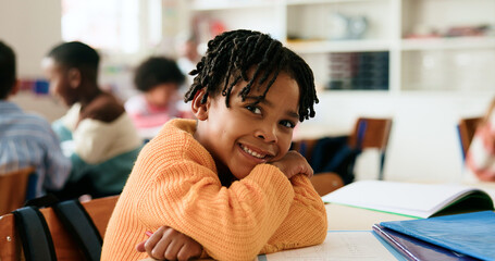 Boy, happy and portrait in classroom with arms crossed, pride and confidence for learning at academy. Kid, smile learner and pupil for education, lesson or development with books at elementary school