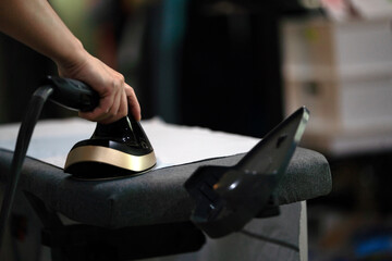 Woman Ironing Clothes with Steam Press at Home