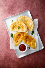 Deep-fried meat pies with tomato sauce