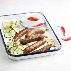 Homemade grilled sausages with cucumber salad