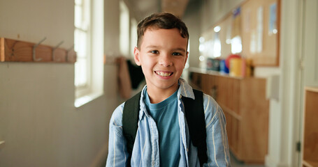 Portrait, child and smile with backpack at school for education, learning and scholarship. Happy, kid and student in hallway for study opportunity, knowledge growth and academic pride in preschool © BuyOutFelix03/peopleimages.com