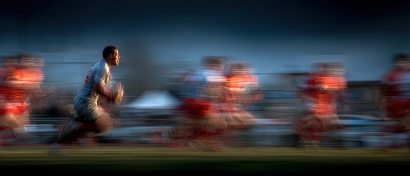 Rugby Player Runs with Ball in Motion Blur