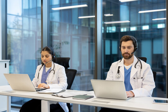 Doctors working with headset and laptop in modern clinic - Powered by Adobe